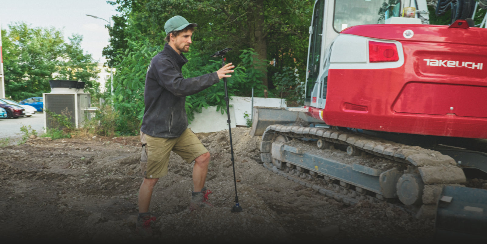 Measuring a job site with the Moasure STICK beside an excavator